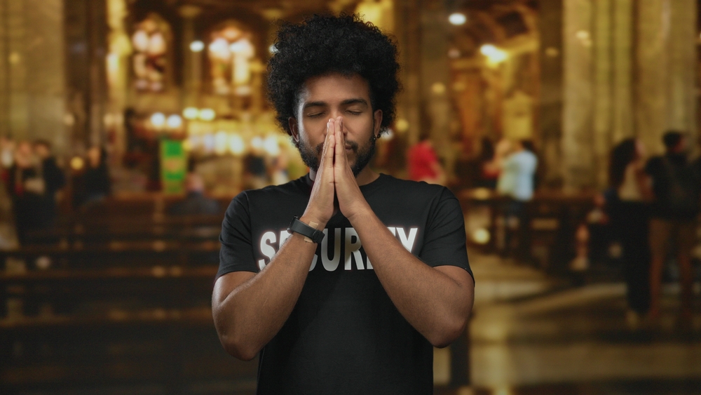 Man,Wearing,Security,Uniform,With,Eyes,Closed,In,Prayer,Inside